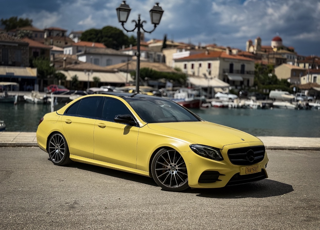 Yellow luxury Mercedes taxi in a Greek harbor